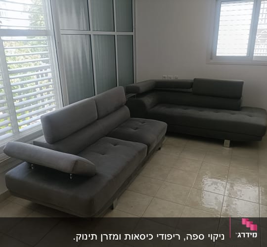 ספות אפורות בחדר עם חלונות גדולים